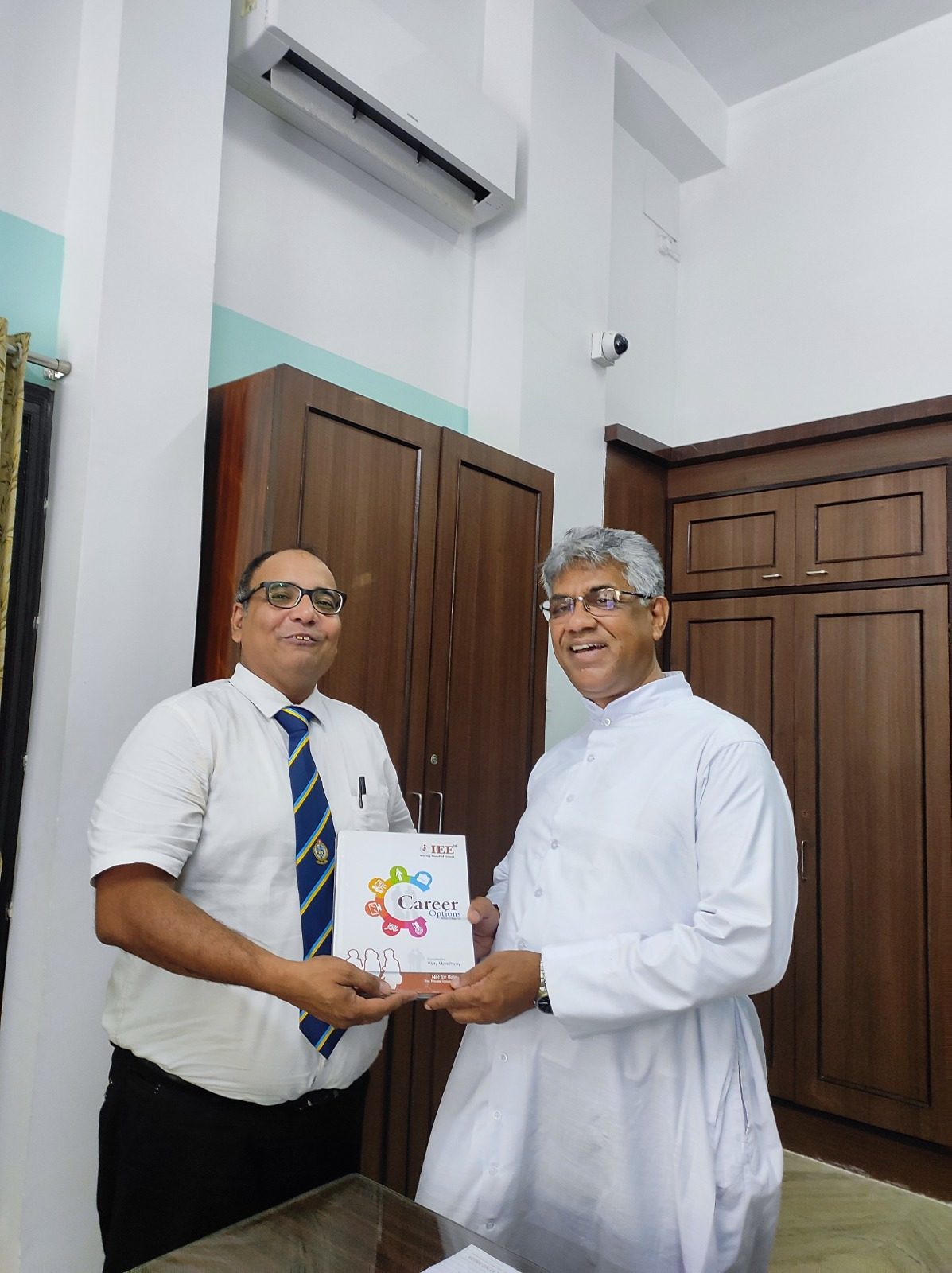 Two men smiling and holding a book titled Career Options