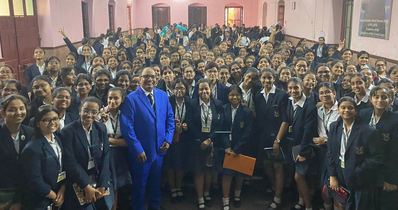 Large group of school students in blazers posing with a speaker after a Learnify session