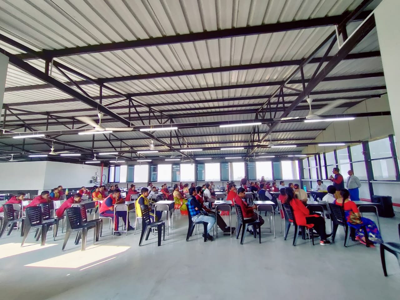 Participants seated at tables in a large hall during a workshop